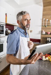 Österreich, Mann in Küche mit digitalem Tablet, sucht nach Rezept - MBEF001259