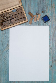 Ein Blatt weißes Papier, ein Holzkästchen mit Holzstempeln und ein Stempelkissen - OPF000004