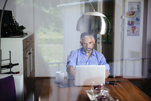 Businessman working with laptop at home office - MBEF001187