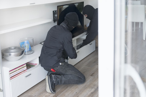Zwei Einbrecher bei der Arbeit in einem Einfamilienhaus zur Tageszeit, lizenzfreies Stockfoto