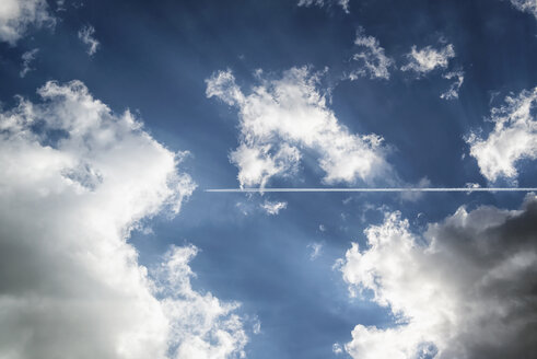 Kondensstreifen eines Flugzeugs am Himmel mit Wolken - OPF000008