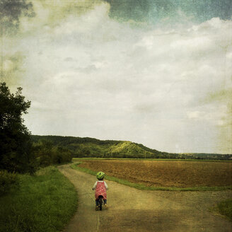Mädchen auf Trainer Fahrrad auf Feldweg - LVF001904