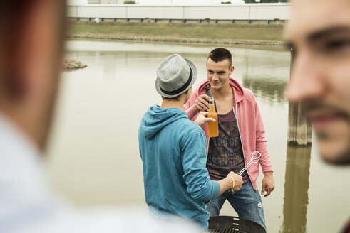 Eine Gruppe von Freunden trinkt Bier und grillt - UUF001898