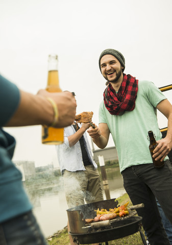 Eine Gruppe von Freunden trinkt Bier und grillt, lizenzfreies Stockfoto