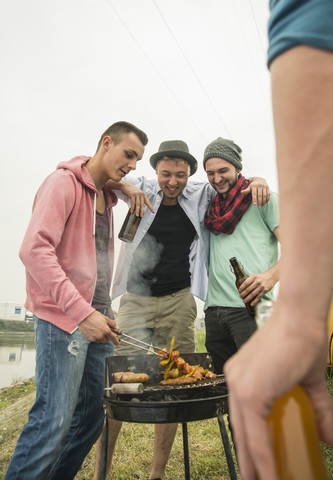 Eine Gruppe von Freunden trinkt Bier und grillt, lizenzfreies Stockfoto