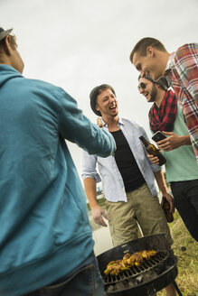 Eine Gruppe von Freunden trinkt Bier und grillt - UUF001871
