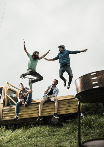 Zwei Freunde springen von einem Pick-up-Truck, lizenzfreies Stockfoto