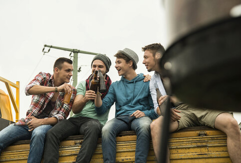 Gruppe von Freunden trinkt Bier auf einem Pick-up-Truck - UUF001880