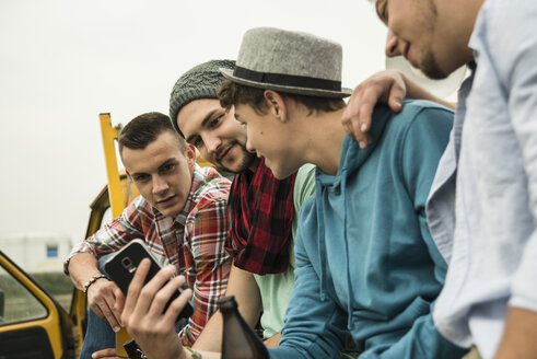 Gruppe von Freunden mit Handy auf einem Pick-up-Truck - UUF001881