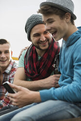 Gruppe von Freunden mit Handy auf einem Pick-up-Truck - UUF001884