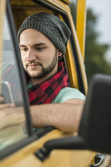 Junger Mann mit Mobiltelefon im Pick-up sitzend - UUF001892