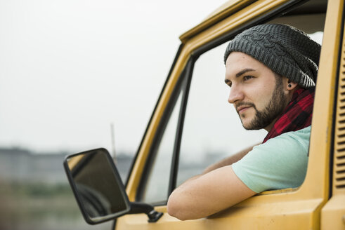Junger Mann sitzt in einem Pick-up und schaut aus dem Fenster - UUF001893