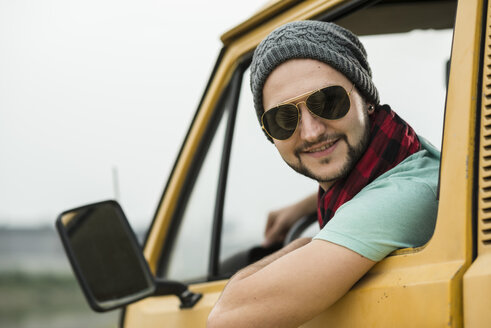 Lächelnder junger Mann in einem Pick-up-Truck - UUF001894