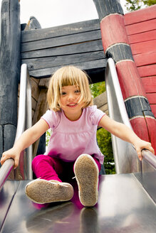 Kleines Mädchen auf Spielplatz auf Rutsche - LVF001889