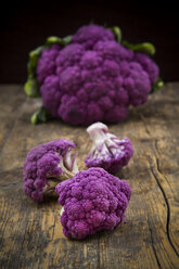 Whole purple cauliflower and cauliflower florets on wood - LVF001894