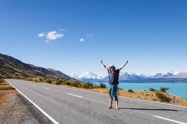 New Zealand, South Island, Lake Pukaki, young man standing on empty road - WVF000650