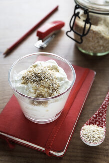 Glas Naturjoghurt mit Eichenkleie auf einem Schreibtisch mit Büroutensilien - EVGF000890