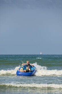 Frankreich, Bretagne, Departement Finistere, Sainte-Anne-la-Palud, Mann mit Kindern in einem Schlauchboot - LAF001138