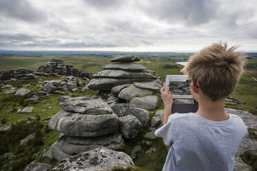 UK, Cornwall, Junge fotografiert Landschaft in Bodmin Moor mit seinem digitalen Tablet - PAF000972