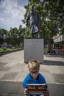 UK, London, Junge steht vor dem Denkmal für Winston Churchill und macht ein Selfie mit seinem digitalen Tablet - PAF000953