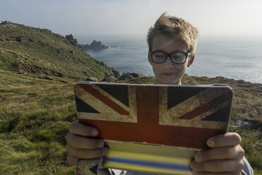 UK, Cornwall, Porträt eines Jungen, der am Land's End ein Selfie mit seinem digitalen Tablet macht - PAF000961