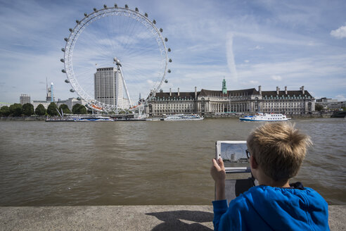 UK, London, Junge fotografiert das London Eye mit seinem digitalen Tablet - PAF000971