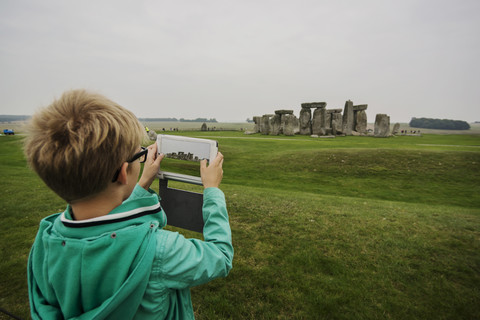 UK, Wiltshire, Junge fotografiert Stonehenge mit seinem digitalen Tablet, lizenzfreies Stockfoto