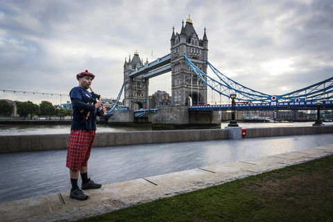 UK, London, Scottish bagpiper at Tower Bridge stock photo