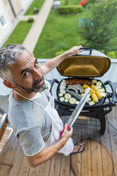 Man barbecuing on his balcony - MBEF001273