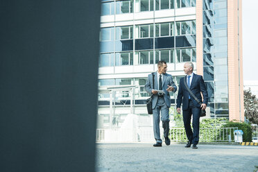 Two businessmen talking outside office building - UUF001944