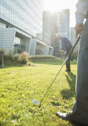 Zwei Geschäftsleute spielen Golf vor einem Bürogebäude - UUF001969