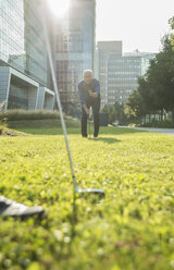 Zwei Geschäftsleute spielen Golf vor einem Bürogebäude - UUF001971