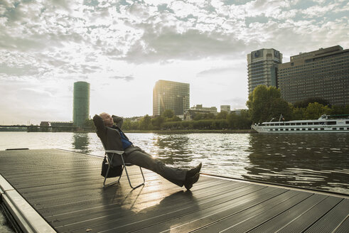 Germany, Frankfurt, relaxed businessman at river Main - UUF001990