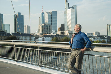 Germany, Frankfurt, businessman on bridge over river Main - UUF001984
