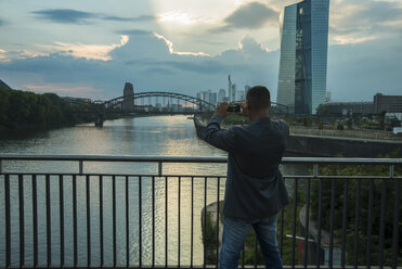 Deutschland, Frankfurt, Mann auf Brücke beim Fotografieren - UUF001993