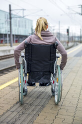 Frau im Rollstuhl wartet am Bahnsteig - EJWF000604