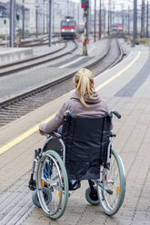 Frau im Rollstuhl wartet am Bahnsteig - EJWF000605