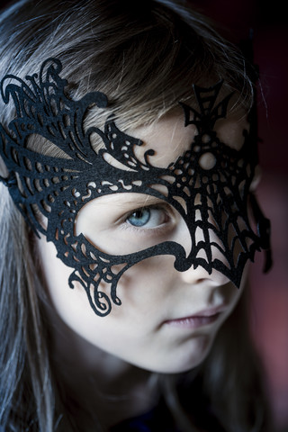 Porträt eines Mädchens mit schwarzer Halloween-Maske, lizenzfreies Stockfoto