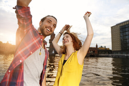 Germany, Berlin, Young couple enjoying sunset at Spree river - FKF000674