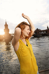 Germany, Berlin, Young woman enjoying sunset at Spree river - FKF000675