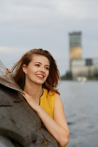 Deutschland, Berlin, Junge Frau genießt Sonnenuntergang an der Spree, lizenzfreies Stockfoto