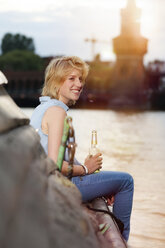 Germany, Berlin, Young woman enjoying sunset at Spree river - FKF000680