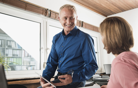 Lächelnder Geschäftsmann und Frau im Büro, lizenzfreies Stockfoto