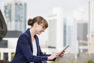 Germany, Hesse, Frankfurt, smiling businesswoman using her digital tablet - FMKYF000538