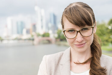 Germany, Hesse, Frankfurt, portrait of smiling businesswoman wearing glasses - FMKYF000558