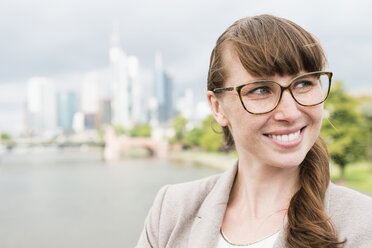 Germany, Hesse, Frankfurt, portrait of smiling businesswoman wearing glasses - FMKYF000559