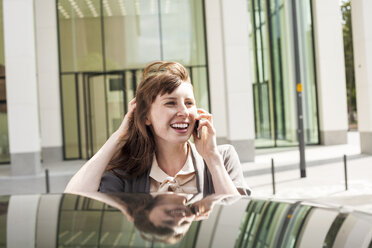 Deutschland, Hessen, Frankfurt, Porträt einer lächelnden Geschäftsfrau, die mit einem Smartphone telefoniert - FMKYF000579