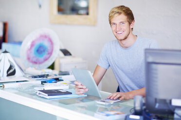 Smiling young man at shop counter - ZEF000230