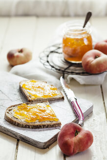 Pfirsichmarmelade auf zwei Scheiben Schwarzbrot und Pfirsichkrapfen - SBDF001256