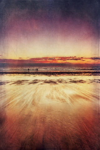 Drei Spaziergänger am Strand bei Sonnenuntergang, lizenzfreies Stockfoto